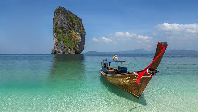 Typisches Bild von Phuket. Kalksteinfelsen in c"Cicken-Island" mit einem typisch thailändischen "Longtail Boot"..